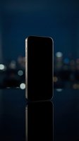 Smartphone with blank black screen displayed against blurred night cityscape with bokeh lights, suitable for app mockups and mobile technology presentations.