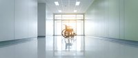 Modern empty office corridor with glass walls and polished floors leading to conference room with meeting table and chairs in bright corporate building interior.