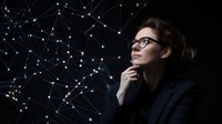 Young professional woman in glasses contemplates against dark background with glowing network connections and dots pattern, representing technology and innovation.