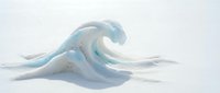 Frozen ocean wave sculpture with translucent blue ice formation on white snow surface creating artistic winter landscape composition.