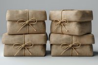 Stacked kraft paper packages tied with twine bows on gray background, perfect for eco-friendly shipping, sustainable packaging, and zero waste lifestyle concepts.