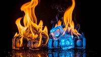 Fire and ice cubes creating dramatic contrast with orange flames and blue glow on reflective surface for creative design projects.