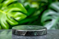Natural green marble podium platform with tropical monstera leaves background for luxury product display and cosmetic presentation.