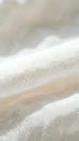 Soft white linen fabric texture with natural wrinkles and folds creating elegant waves for textile and fashion design projects.