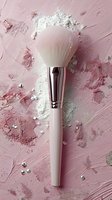 Makeup brush with loose powder on pink textured background with scattered rhinestones, creating luxurious beauty cosmetics composition for professional artists.