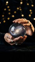 Fortune teller hands holding crystal ball with galaxy stars universe inside against bokeh lights background for mystical divination readings.