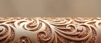 Ornate copper metallic surface with intricate swirling baroque patterns and decorative scrollwork creating elegant textured background for luxury design projects.