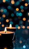 Glowing candles against dark background with turquoise and golden bokeh lights creating magical atmosphere for meditation, spa or holiday season.