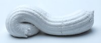 Close-up of white textured paste or clay with curved, organic shape on neutral background. Suitable for cosmetics, skincare, art materials, and design projects.