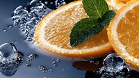Fresh orange slices with mint leaves and ice cubes on dark background with water drops, macro shot showing juicy citrus texture and refreshing details.