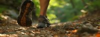 Close-up of hiking boots on forest trail with fallen leaves, outdoor adventure and nature walking concept for active lifestyle and wilderness exploration.