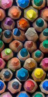 Vibrant macro view of colored pencil tips arranged in a honeycomb pattern, showcasing diverse hues and textures perfect for education, creativity, and artistic design backgrounds.