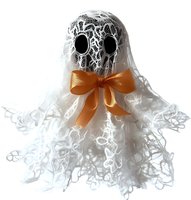 Decorative ghost made from white lace fabric with orange bow tie on isolated background, spooky yet elegant Halloween decoration for seasonal displays.