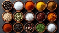 Colorful spices and seasonings in wooden bowls arranged on dark background, including peppercorns, salt, turmeric, paprika, cumin and other aromatic ingredients.