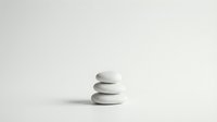 Zen stone stack on minimalist white background for meditation wellness spa and balance concepts in clean modern style.