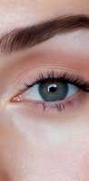 Close-up of blue eye with long eyelashes and coral eyeshadow showing detailed iris pattern and natural brow shape, suitable for beauty and cosmetic advertising.