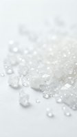 Translucent crystalline sugar granules scattered on white surface with shallow depth of field, suitable for food, baking, and culinary design projects.