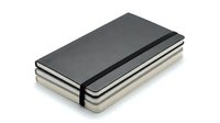 Stack of three hardcover notebooks with elastic band closure in gray and beige tones, isolated on white background for design use.