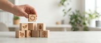 Hand placing wooden block with eco icons forming pyramid, sustainability and green energy concept for business and environment.