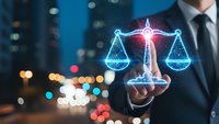 Businessman touching glowing digital scales of justice hologram against blurred city lights background representing legal technology and law firm services.