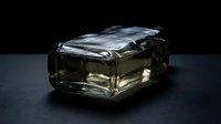 Luxury fragrance bottle with clear glass and metallic silver cap on dark surface, suitable for perfume, cologne, and beauty product marketing.