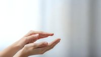 Open cupped hands in protective gesture against soft blurred background suggesting care, support, protection, safety and helping concepts for healthcare design.