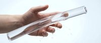 Hand holding transparent glass test tube for laboratory research and scientific experiments on white background.