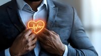 Professional African American man in business suit holding glowing heart with pulse line, representing healthcare, wellness and cardiovascular care concept.