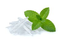 Fresh green mint leaves with crushed ice crystals on white background, isolated and ready for beverage, culinary, wellness and food styling design projects.