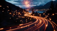 Winding mountain highway with light trails and fireworks illuminating night sky over scenic lake and city lights, creating magical long exposure effect.