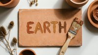 Terracotta tile with embossed earth text and paintbrush, surrounded by clay bowls and dried botanicals on white surface for eco-friendly design projects.