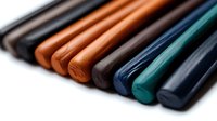 Colorful polymer clay sticks arranged in diagonal rows showing texture and vibrant colors with selective focus on brown and orange tones against white background.