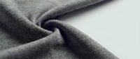 Soft gray fabric texture with natural folds and wrinkles, showcasing textile material detail for fashion design, upholstery and interior decoration projects.