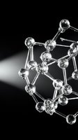 Glass molecular structure model with spherical atoms and connecting bonds on black background for scientific research and chemistry education.