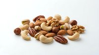 Mixed nuts assortment with walnuts, almonds, cashews, pecans and hazelnuts on white background for healthy snacking and cooking ingredients.