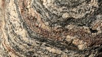 Weathered stone surface with natural cracks and earthy brown tones, suitable for backgrounds, textures, and construction or geology projects.