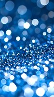 Magical blue glitter bokeh background with sparkling defocused lights creating dreamy atmosphere for festive designs and holiday celebrations.