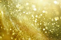 Magical golden bokeh effect with sparkling glitter particles floating in blurred motion against warm yellow background, creating dreamy festive atmosphere.