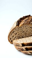 Freshly baked artisan sourdough bread loaf with rustic crust and airy crumb texture sliced on white background for bakery and food photography.