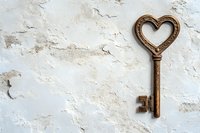 Vintage bronze heart-shaped key on weathered white wooden background with peeling paint texture for romantic design projects.