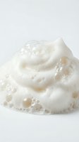 Creamy white soap foam with bubbles on a light background, perfect for skincare, cosmetic cleanser, and beauty product advertising concepts.