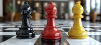 Colorful chess bishops in black, red and yellow stand on checkered board, showing strategic game pieces with glossy finish and selective focus on pieces.
