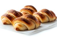 Fresh baked crescent rolls with golden brown crust arranged on white plate. Close up view of homemade buttery pastries showing flaky texture and shine.
