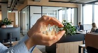 Businessman hands protecting glowing team icons in modern office space representing employee care, human resources management and corporate responsibility.