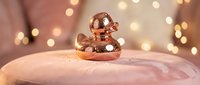 Copper meditation singing bowl on wooden surface with warm bokeh lights creating peaceful zen atmosphere for mindfulness practice and relaxation.