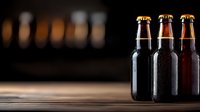 Cold dark beer bottles with water drops on wooden table against dark background, dramatic lighting creates moody atmosphere for beverage photography.