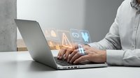 Man in white shirt typing on laptop with glowing digital icons floating above keyboard, representing technology, data processing, and business software applications for web design.
