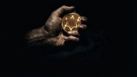Close-up of weathered hand holding glowing golden star against dark background, symbolizing achievement, success, and aspirational goals for business concepts.