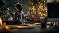 Young African American woman practicing meditation in peaceful home environment with warm natural lighting and plants creating zen atmosphere.