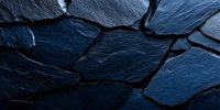 Dark blue slate stone wall texture with rough irregular pieces creating natural pattern. Dramatic lighting highlights surface details and cracks. For architecture backgrounds.